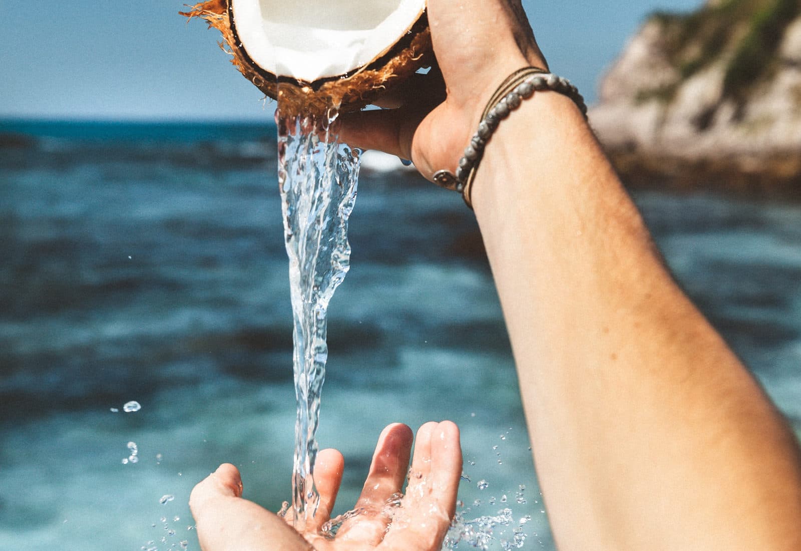 Fresh coconut water poured by the sea
